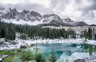 Karersee lake with snow in the Dolomites, Italy.