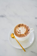Hot art latte coffee in a cup on white table background.