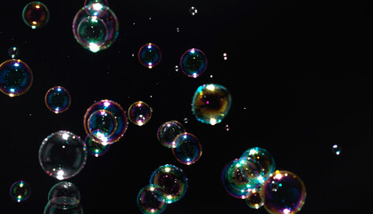 Beautiful Soap Bubbles Floating in The Dark. Abstract Background. Celebration Festive Backdrop. Freshness Soap Suds Bubbles Water on Black Background.	