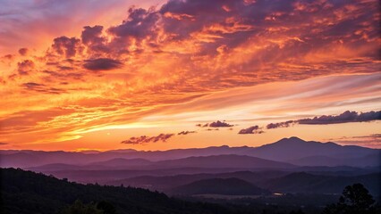 Obraz premium A vibrant orange and purple sunset sky fills the frame with a breathtaking panorama of mountains in the distance, panoramic views, vast landscape