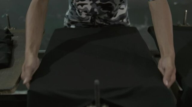 preparing t-shirt for printing. man holding black shirt an put it on the printing table