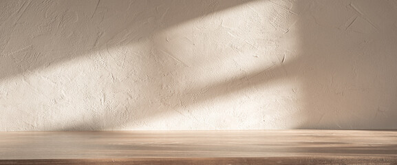 Gentle sunlight filters through, creating calming shadows on a textured wall and a wooden surface,...