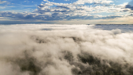 Flying above the clouds at dawn in autumn