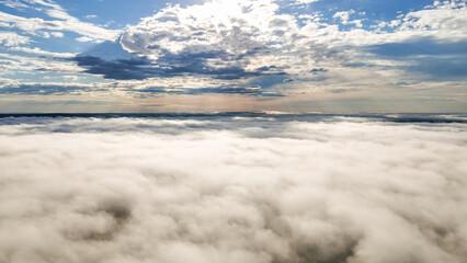 Flying above the clouds at dawn in autumn