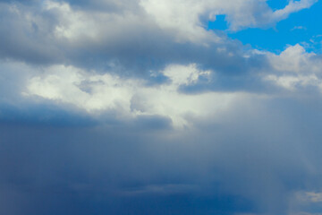 Cumulus clouds. Beautiful dark blue dramatic sky. Copy space for lettering. Few clouds against a blue sky on a sunny day.