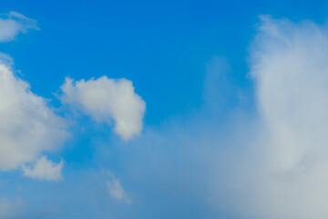 Cumulus clouds. Beautiful dark blue dramatic sky. Copy space for lettering. Few clouds against a blue sky on a sunny day.