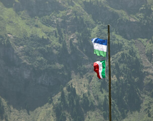 flag of Italy and flag of Ladinia the  Alpine region in the Dolomites mountain range of Italy