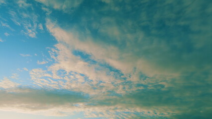 Clouds in different shades. White cirrus clouds during sunset moving different directions.