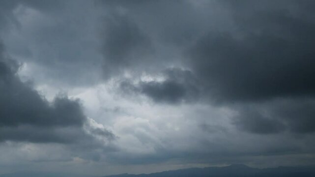 Timelapse of dark clouds moving quickly in the sky when it is about to rain. Weather and climate concept. For environmental theme videos. The pattern and texture of dark, lumpy clouds. Footage 4K,60Fp
