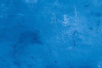 Grunge classic blue concrete background. Textured plaster wall. Creative backdrop for your design. Color of the year 2025 concept. Top view, layout for design. Surface with peeling shabby pattern.