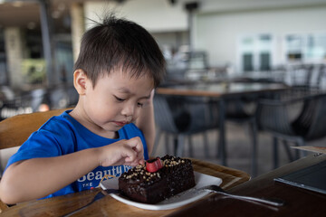 Happy Kid enjoying a slide of chocolate cake