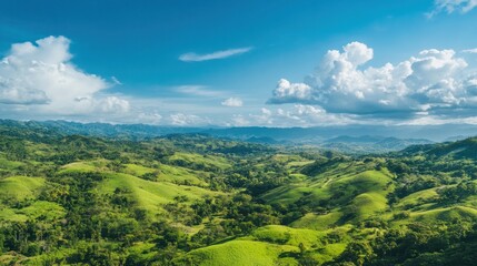 Naklejka premium Vibrant green hills stretching to the horizon, under a wide-open blue sky