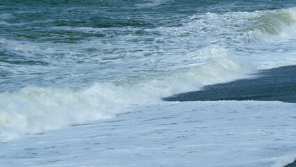 View Of Big Waves. Beautiful Splashing Stormy Sea Water Background. Sea Surf On Beach With Black Volcanic Sand. Real time.