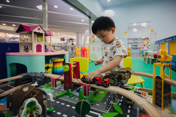 Happy 3 years old boy having a fun time at indoor playground