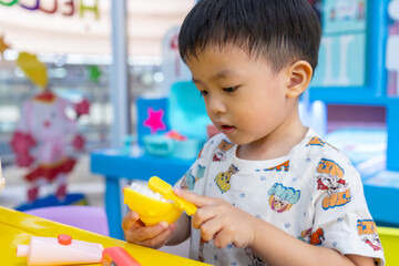 Happy 3 years old boy having a fun time at indoor playground