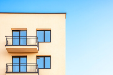 Modern residential building with balconies against a clear blue sky during daytime