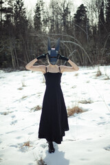 Woman in Black Dress with Rabbit Mask in Snow