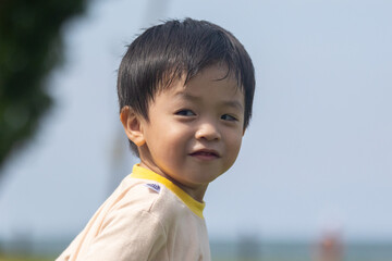 Happy asian toddler smiling outdoors in a park