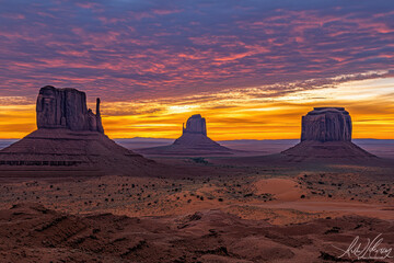 A stunning sunrise over Monument Valley, showcasing iconic rock formations and vibrant skies.