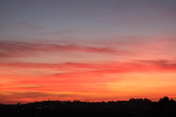 Panoramic sunrise or sunset dusk dawn landscape nature coastal scenery with beautiful fire sky and dramatic cloudscapes over California coast range view near Los Angeles