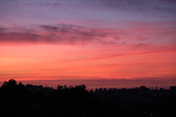 Panoramic sunrise or sunset dusk dawn landscape nature coastal scenery with beautiful fire sky and dramatic cloudscapes over California coast range view near Los Angeles
