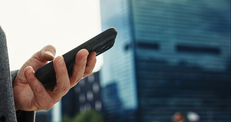 Message, outdoor and hand with smartphone, browsing and networking with contact, corporate and typing. City, tech and person with mobile, communication and texting for business, legal and lawyer