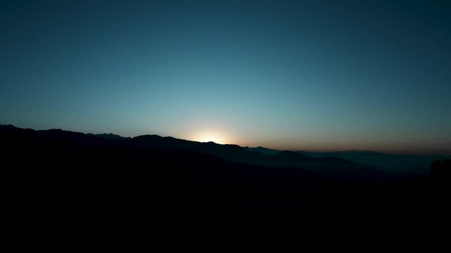 Sunrise time-lapse in the mountain on a clear morning. 