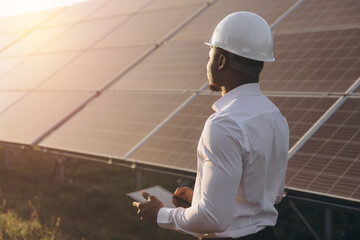 African American Engineer Inspecting Solar Panels at a Renewable Energy Site © anatoliycherkas