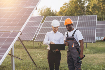 Engineers Collaborating at Solar Panel Farm With Laptop Outdoors