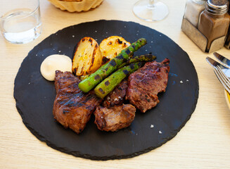 Healthy dinner, baked veal steak with vegetable garnish of potato and asparagus