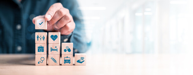Health insurance concept. healthcare medical wooden cube block with icon, health and access to welfare health concept © phimprapha
