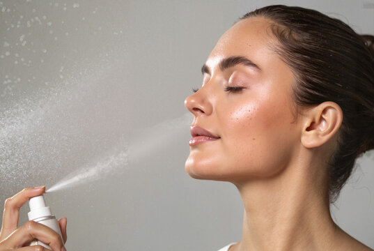 Woman applying face mist for hydration

