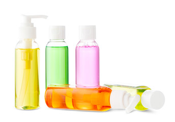 Variety of colorful personal care bottles and grooming accessories arranged on a white surface