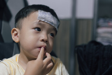 Young kid with a fever cooling gel sheet on her forehead