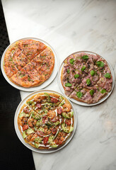 Top view of three pizza on a marble table background with copy space. A pizza restaurant