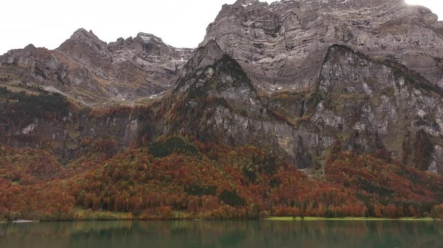 Rocky Mountain Vorder Glarnisch With Autumn Foliage And Lake Klontal In Foreground. Glarus, Switzerland. wide zoom-in