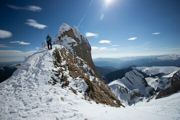 A lone hiker gazing at a majestic, snow-covered mountain peak