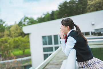 学校の屋上から大声で叫ぶポニーテールの女子生徒