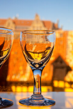 Close up of two wine glasses on a table, and view over the historic rooftops of Malmo city, Sweden.