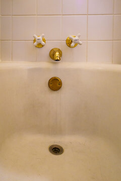 Close-up of old-fashioned bathtub faucets,  brass taps and plughole. 
