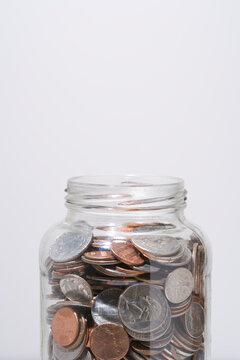 Close up of US silver and coppper coins in a glass jar.