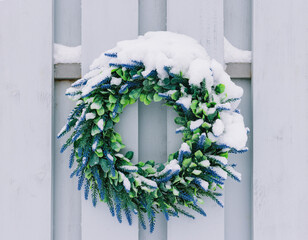 Snow covered wreath on old weathered barn in snow winter time. © Ekaterina Kondratova