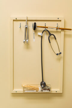 Close up of a reflex hammer, stethoscope and other medical tools.