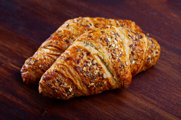 Tasty dessert – puff pastry croissant with sesame seed on table