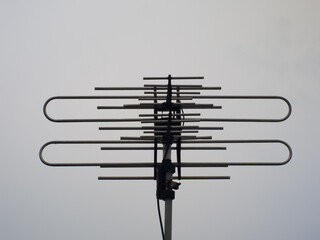 Television antenna with cloudy sky background.