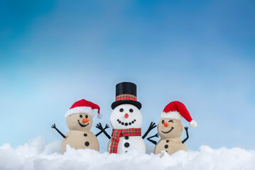 A joyful snowman and two sandy snowmen pose together for a Christmas and New Year celebration! With a snowy backdrop and blue sky, this mix of winter and beach vibes brings a fresh holiday twist.