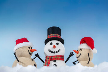 A joyful snowman and two sandy snowmen pose together for a Christmas and New Year celebration! With a snowy backdrop and blue sky, this mix of winter and beach vibes brings a fresh holiday twist.