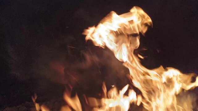 Beautiful dancing fire, the surface is ablaze. Lots of fire. Burning tongues of flame on a black backdrop in slow motion. 4K footage