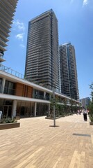 Modern urban scene featuring tall buildings and a pedestrian walkway.