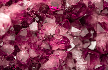 Amethyst garnet crystals. Burgundy gemstone. Mineral crystals in the natural environment. Texture of precious and semiprecious stones. Colored shiny surface of precious stones.